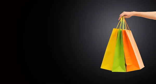 Close up of hand holding shopping bags — Stock Photo, Image