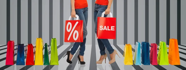 Close up of women with sale sign on shopping bag — Stock Photo, Image