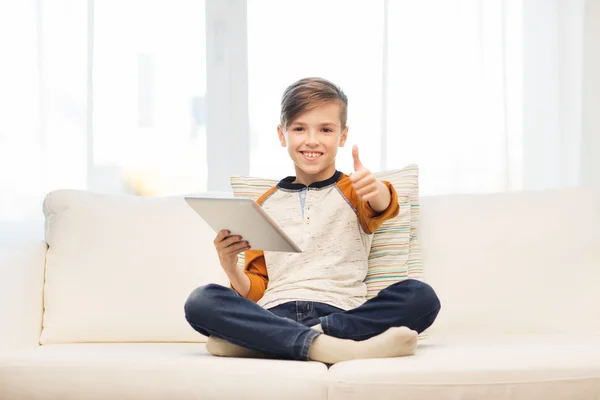 Glimlachende jongen met tablet tonen duimen omhoog thuis — Stockfoto