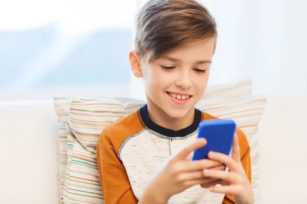 Menino com mensagens de texto smartphone ou jogar em casa — Fotografia de Stock