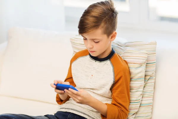 Garçon avec smartphone textos ou jouer à la maison — Photo