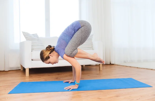 Frau macht Yoga in Kranichpose auf Matte — Stockfoto