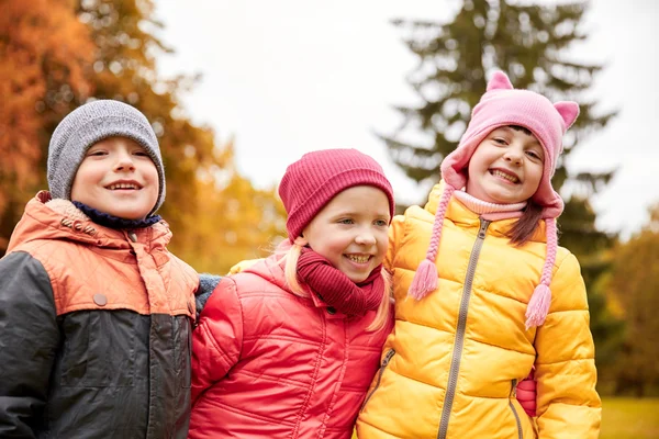 Grupo de niños felices abrazándose en el parque de otoño —  Fotos de Stock