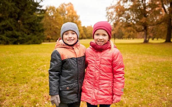 Счастливые девочка и мальчик в осеннем парке — стоковое фото