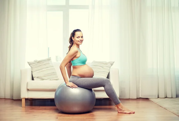 Heureuse femme enceinte exerçant sur fitball à la maison — Photo