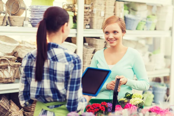 Gelukkig vrouwen met tablet pc op bloemenwinkel — Stockfoto