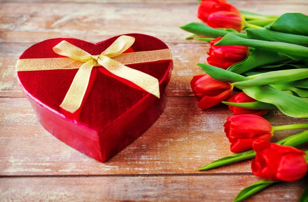 Primo piano di tulipani rossi e scatola di cioccolato — Foto Stock