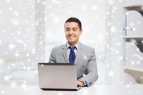 Счастливый бизнесмен, работающий с ноутбуком в офисе — стоковое фото