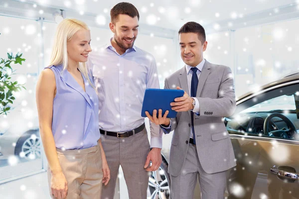 Casal feliz com revendedor de carro em auto show ou salão — Fotografia de Stock