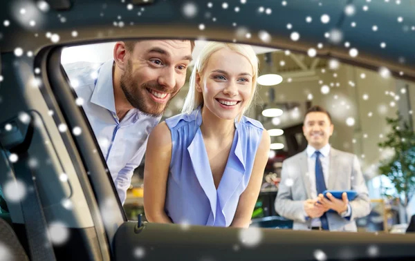 Happy couple looking inside car in auto show — Φωτογραφία Αρχείου