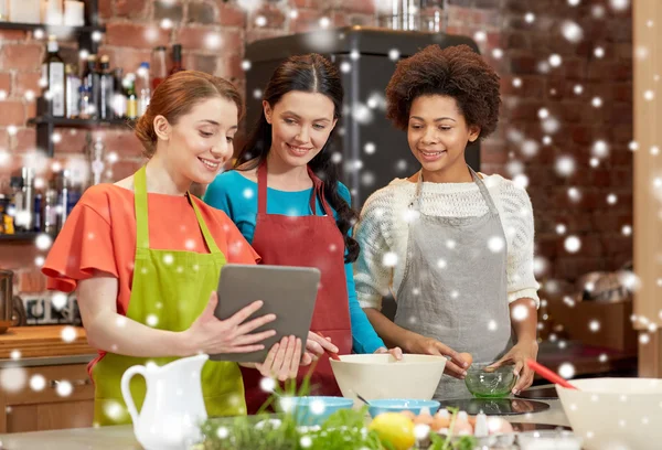 Happy women with tablet pc cooking in kitchen — Stock Photo, Image