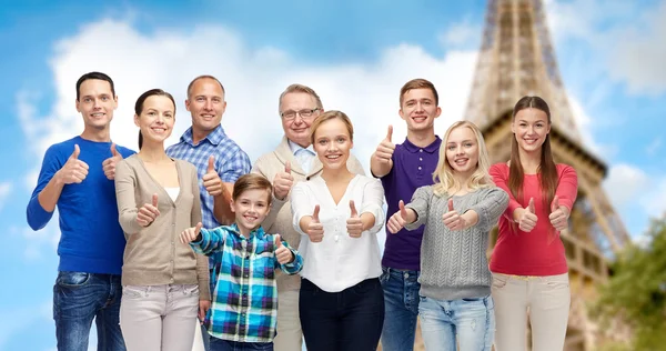 Sorrindo pessoas mostrando polegares por cima da torre eiffel — Fotografia de Stock