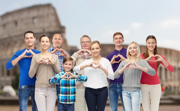 Personnes heureuses montrant signe de main de coeur sur le colisée — Photo