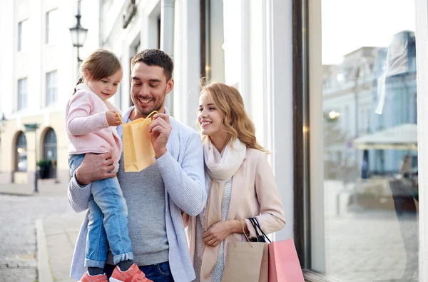 Gelukkig gezin met kind en boodschappentassen in stad — Stockfoto