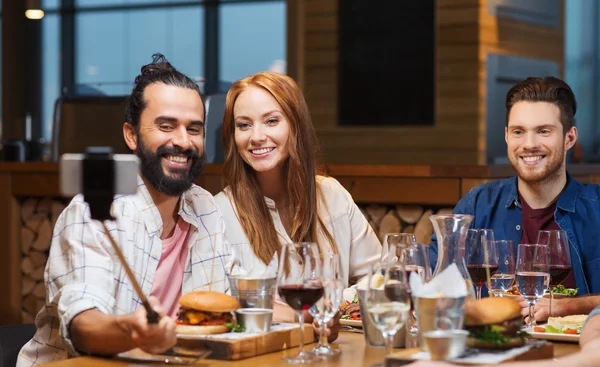 Friends taking selfie by smartphone at restaurant — Stock Photo, Image