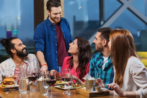 Přátelé stolování a pití vína v restauraci — Stock fotografie