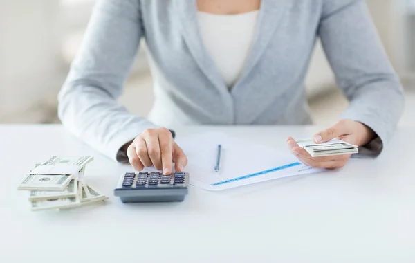 Close up of hands counting money with calculator — Stock Photo, Image