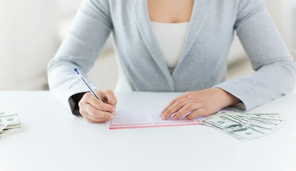 Nahaufnahme einer Frau mit Lottoschein und Geld — Stockfoto