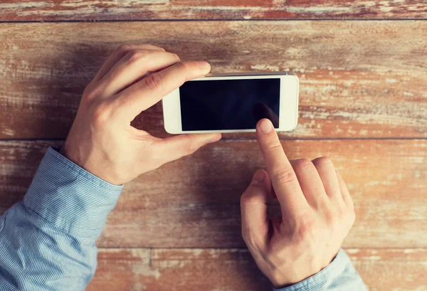 Primer plano de las manos masculinas con smartphone en la mesa — Foto de Stock