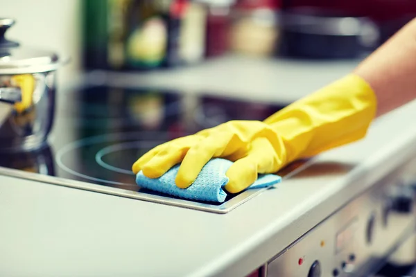 Close up of woman cleaning cooker at home kitchen — Stock Photo, Image