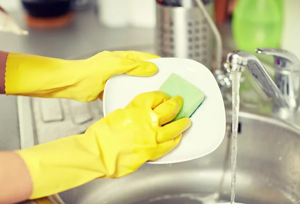 Primo piano di mani di donna che lavano piatti in cucina — Foto Stock