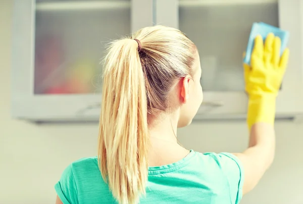 Lycklig kvinna rengöring skåp på hem kök — Stockfoto