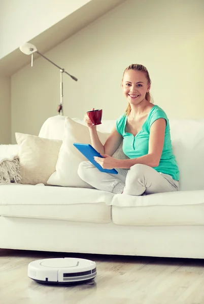 Mujer feliz con la tableta pc beber té en casa —  Fotos de Stock