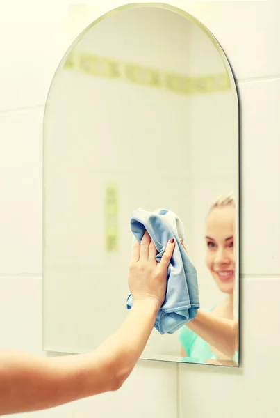 Close up of happy woman cleaning mirror with rag — Stock Photo, Image