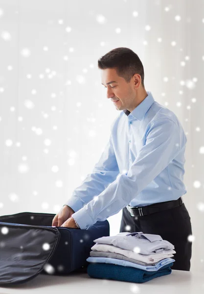 Homem de negócios embalando roupas em saco de viagem — Fotografia de Stock