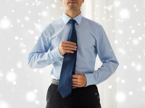 Close up of man in shirt adjusting tie on neck — Stock Photo, Image