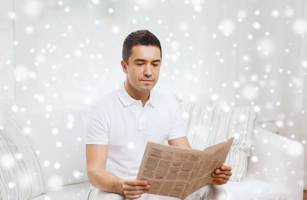 Een man die thuis kranten leest — Stockfoto