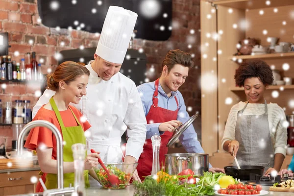 Glückliche Freunde und Koch kochen in der Küche — Stockfoto