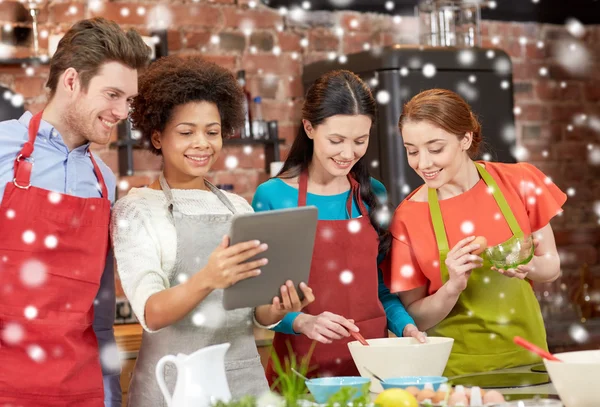 Amigos felizes com tablet pc cozinhar na cozinha — Fotografia de Stock