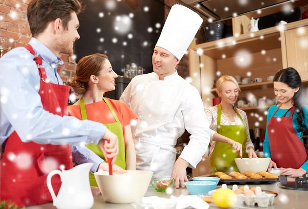 Glückliche Freunde und Koch backen in der Küche — Stockfoto