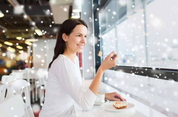 Lächelnde junge Frau mit Kuchen und Kaffee im Café — Stockfoto