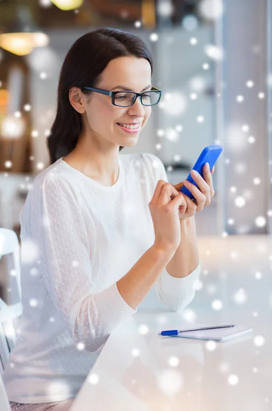 Mujer sonriente con teléfono inteligente en la cafetería —  Fotos de Stock