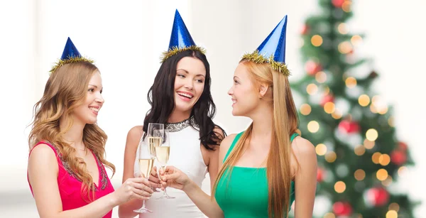 Tre kvinnor som bär hattar med champagneglas — Stockfoto