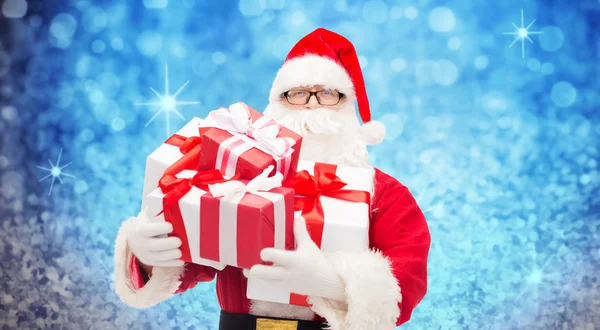 Homem em traje de santa claus com caixas de presente — Fotografia de Stock