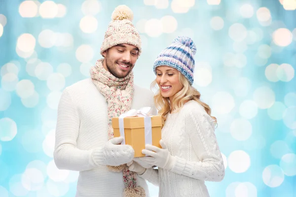 Smiling couple in winter clothes with gift box — Stock Photo, Image