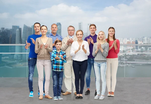 Group of people applauding over city waterside — Stock Photo, Image