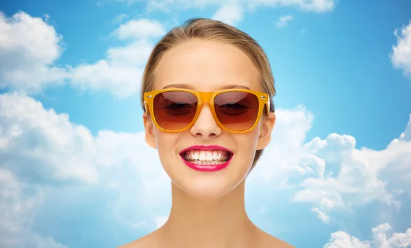 Heureuse jeune femme en lunettes de soleil avec rouge à lèvres rose — Photo