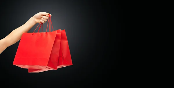 Close up of hand holding red shopping bags — 스톡 사진