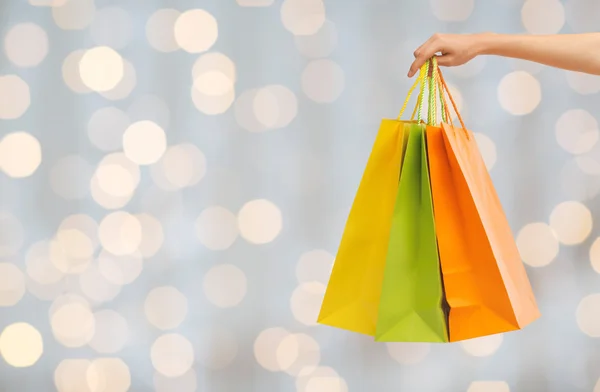 Close up of hand holding shopping bags — Stock Photo, Image