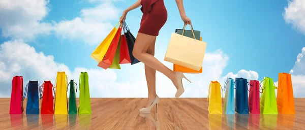 Close up of woman on high heels with shopping bags — Stockfoto