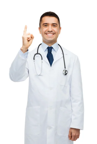 Glücklicher Arzt im weißen Kittel zeigt mit dem Finger nach oben — Stockfoto