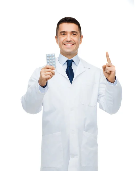 Medico maschio sorridente in mantello bianco con compresse — Foto Stock