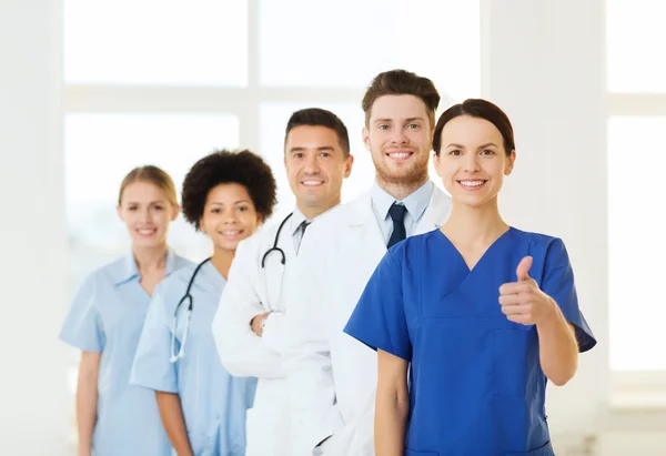 Medici felici mostrando pollici in alto in ospedale — Foto Stock