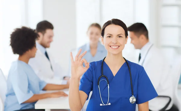 Zufriedener Arzt über Gruppe von Sanitätern im Krankenhaus — Stockfoto