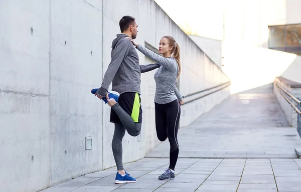 Lächelndes Paar streckt Bein im Freien — Stockfoto