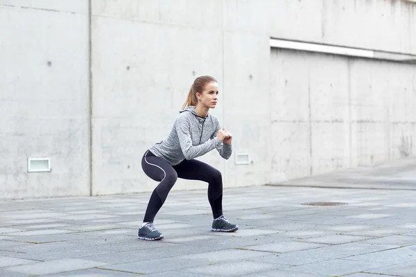 スクワットをして屋外で運動の女性 — ストック写真